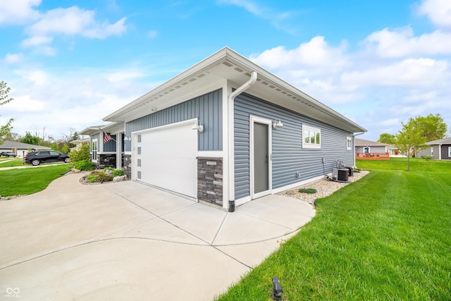 655 N Sobota Way, Trafalgar, IN 46181 - view of home's exterior featuring central AC, a lawn, stone siding, driveway, and an attached garage