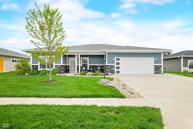 655 N Sobota Way, Trafalgar, IN 46181 - view of front of home featuring stone siding, a garage, concrete driveway, and a front lawn
