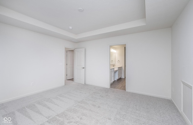 7151 Firestone Rd, Whitestown, IN 46052 - unfurnished bedroom with light carpet, a raised ceiling, baseboards, and ensuite bathroom