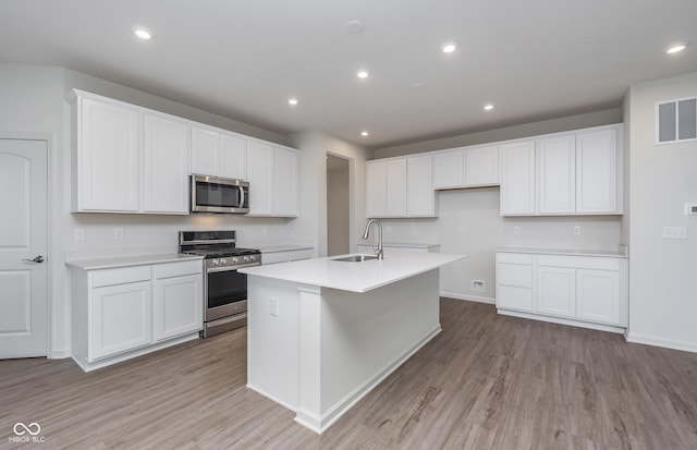 7151 Firestone Rd, Whitestown, IN 46052 - kitchen featuring appliances with stainless steel finishes, a sink, light wood-style flooring, white cabinetry, and recessed lighting