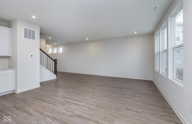 7151 Firestone Rd, Whitestown, IN 46052 - unfurnished room featuring stairs, light wood-style floors, recessed lighting, and baseboards
