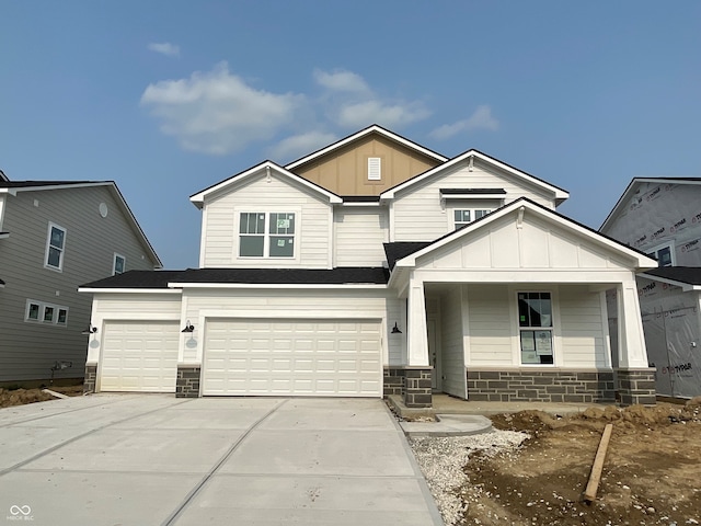 7151 Firestone Rd, Whitestown, IN 46052 - view of front facade with board and batten siding, stone siding, driveway, a porch, and an attached garage