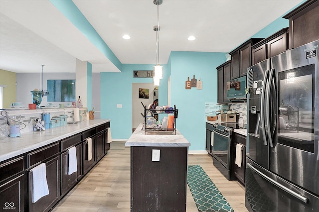 10902 Jimmy Lake Dr, Indianapolis, IN 46239 - kitchen featuring appliances with stainless steel finishes, a kitchen island, light wood finished floors, decorative backsplash, and light countertops