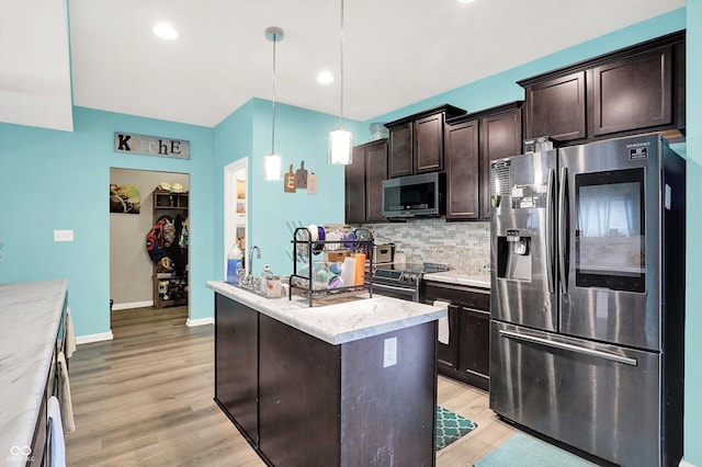 10902 Jimmy Lake Dr, Indianapolis, IN 46239 - kitchen featuring stainless steel appliances, a center island, dark brown cabinets, light wood-type flooring, and recessed lighting
