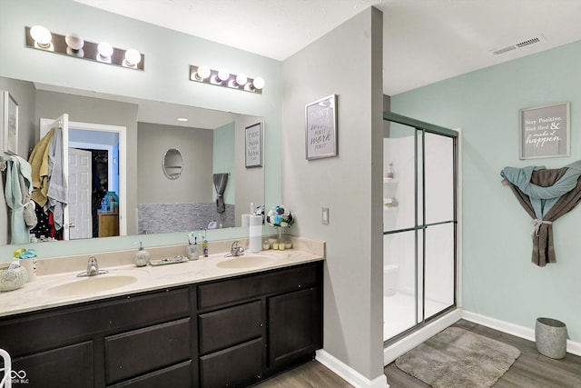 10902 Jimmy Lake Dr, Indianapolis, IN 46239 - bathroom featuring wood finished floors, a stall shower, and double vanity