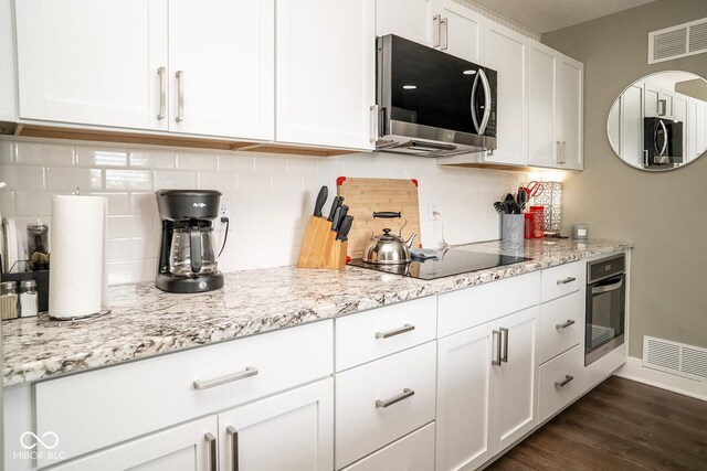 6180 Winnpeny Ln, Indianapolis, IN 46220 - kitchen with stainless steel appliances, white cabinetry, backsplash, and dark wood finished floors