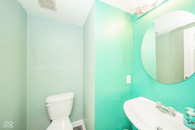 1139 Maple Stream Dr, Indianapolis, IN 46217 - half bathroom with a sink, toilet, and a textured ceiling