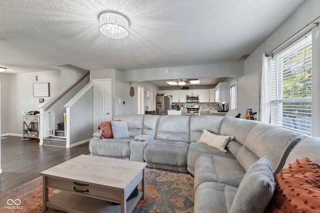6608 Sonesta Dr, Indianapolis, IN 46217 - living area featuring stairs, dark wood-style floors, a textured ceiling, and a chandelier