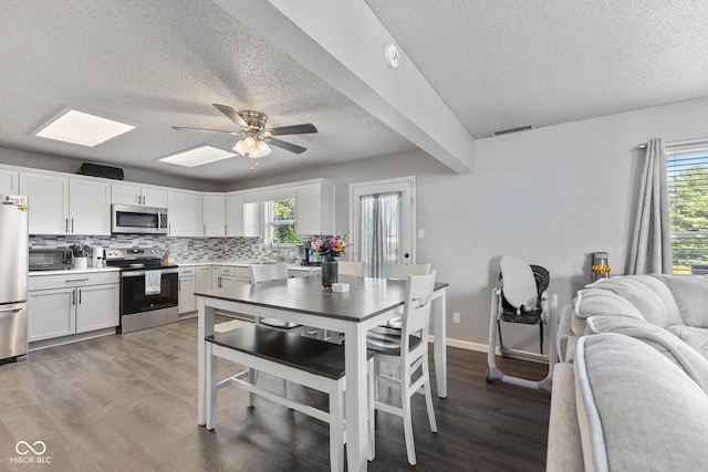 6608 Sonesta Dr, Indianapolis, IN 46217 - kitchen featuring appliances with stainless steel finishes, a textured ceiling, ceiling fan, wood finished floors, and tasteful backsplash