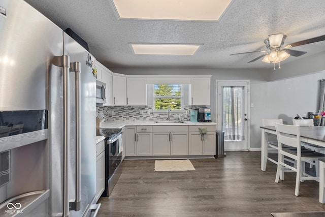 6608 Sonesta Dr, Indianapolis, IN 46217 - kitchen with appliances with stainless steel finishes, light countertops, ceiling fan, backsplash, and white cabinets