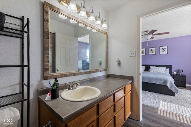 6608 Sonesta Dr, Indianapolis, IN 46217 - bathroom with wood finished floors, vanity, ceiling fan, ensuite bath, and a textured ceiling