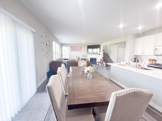 2358 S Stonehill Way, New Palestine, IN 46163 - dining room featuring light wood-style flooring, a glass covered fireplace, and recessed lighting
