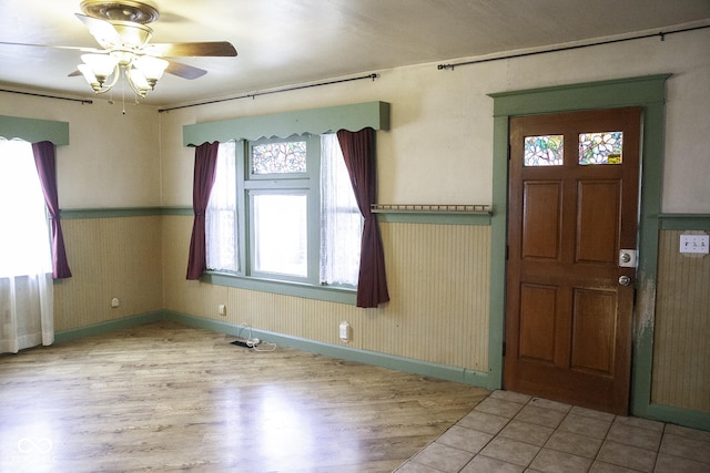1115 N Kealing Ave, Indianapolis, IN 46201 - foyer entrance featuring wood finished floors, a ceiling fan, baseboards, and a wainscoted wall