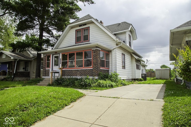 1115 N Kealing Ave, Indianapolis, IN 46201 - view of front of property with brick siding, a front yard, and roof with shingles
