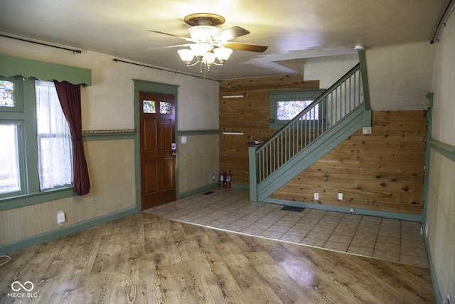 1115 N Kealing Ave, Indianapolis, IN 46201 - foyer featuring wooden walls, healthy amount of natural light, a ceiling fan, stairway, and wood finished floors