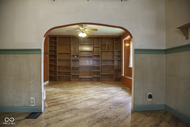 1115 N Kealing Ave, Indianapolis, IN 46201 - spare room with arched walkways, ceiling fan, wood finished floors, a wainscoted wall, and wooden walls