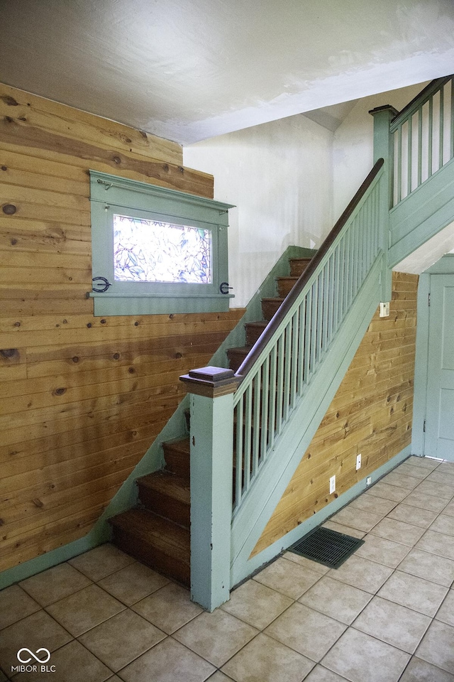 1115 N Kealing Ave, Indianapolis, IN 46201 - stairs with wood walls and tile patterned floors