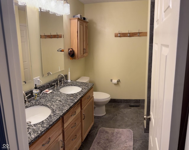 8926 Durban Ct, Indianapolis, IN 46234 - bathroom featuring toilet, double vanity, baseboards, and tile patterned floors