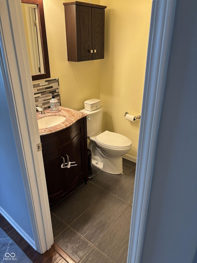 8926 Durban Ct, Indianapolis, IN 46234 - bathroom with vanity, baseboards, toilet, backsplash, and wood finished floors