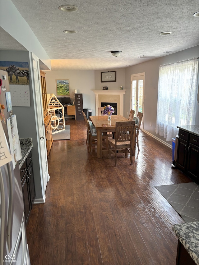 8926 Durban Ct, Indianapolis, IN 46234 - dining area with dark wood-style flooring, a fireplace, a textured ceiling, and baseboards