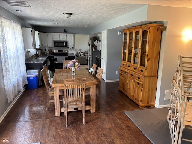8926 Durban Ct, Indianapolis, IN 46234 - dining space with a textured ceiling, dark wood finished floors, and baseboards