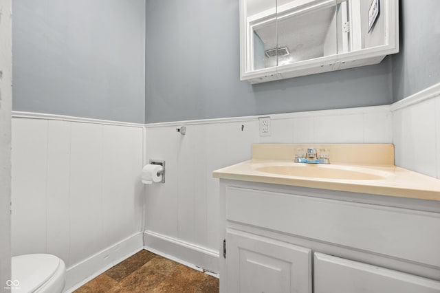 379 N Marion St, Morgantown, IN 46160 - bathroom featuring vanity, toilet, a wainscoted wall, and a decorative wall