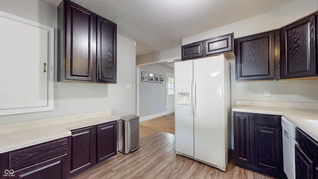 311 S 6th Ave, Beech Grove, IN 46107 - kitchen featuring white fridge with ice dispenser, light wood-style floors, light countertops, dark brown cabinets, and a textured ceiling