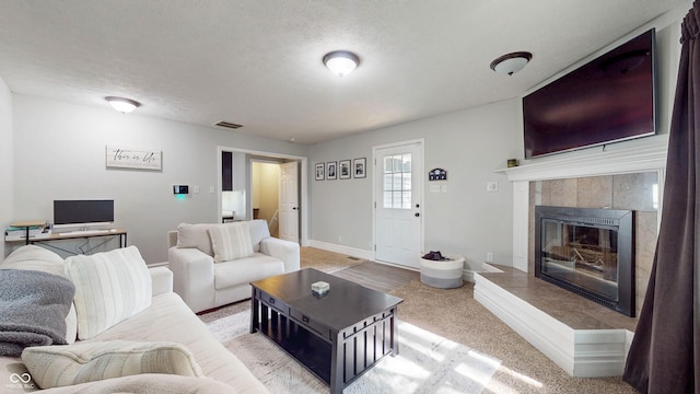 311 S 6th Ave, Beech Grove, IN 46107 - carpeted living room featuring a tile fireplace, a textured ceiling, and baseboards