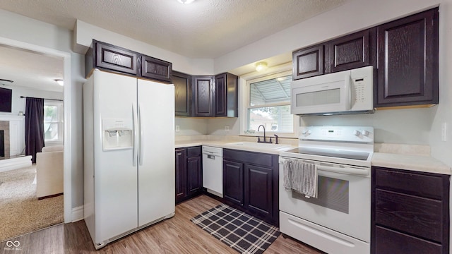 311 S 6th Ave, Beech Grove, IN 46107 - kitchen with white appliances, a sink, light countertops, light wood-style flooring, and a textured ceiling