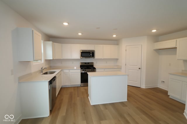 3917 Highcrest Rd, Indianapolis, IN 46239 - kitchen featuring appliances with stainless steel finishes, a sink, recessed lighting, light wood-style flooring, and white cabinetry