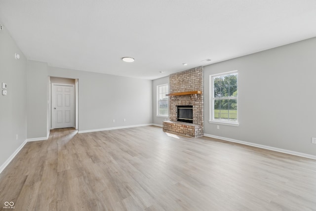 9949 Nightsong Ln, Avon, IN 46123 - unfurnished living room featuring light wood finished floors, baseboards, and a fireplace