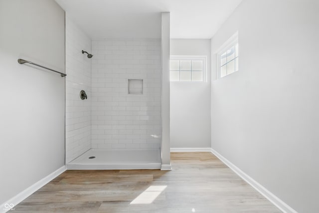 9949 Nightsong Ln, Avon, IN 46123 - bathroom featuring tiled shower, wood finished floors, and baseboards