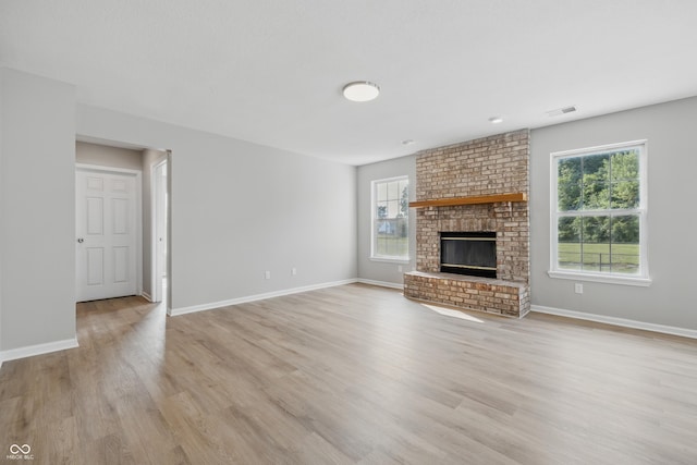 9949 Nightsong Ln, Avon, IN 46123 - unfurnished living room featuring plenty of natural light, light wood-style flooring, baseboards, and a brick fireplace