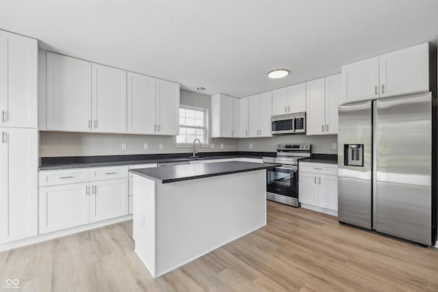 9949 Nightsong Ln, Avon, IN 46123 - kitchen featuring stainless steel appliances, a sink, dark countertops, and white cabinetry