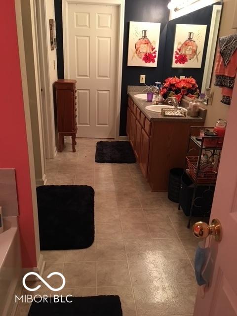 6730 NW Shanghai Cir, Indianapolis, IN 46268 - full bath featuring tile patterned floors, vanity, and a bathtub