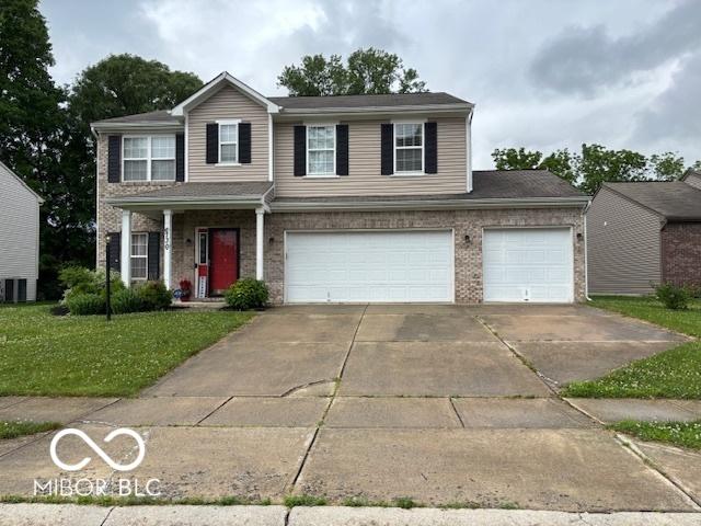 6730 NW Shanghai Cir, Indianapolis, IN 46268 - traditional home featuring concrete driveway, a front yard, brick siding, and an attached garage