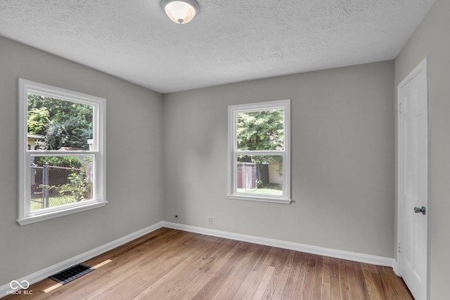 4708 Haverford Ave, Indianapolis, IN 46205 - empty room with plenty of natural light, hardwood / wood-style floors, and a textured ceiling