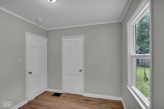 4708 Haverford Ave, Indianapolis, IN 46205 - unfurnished bedroom with multiple windows, wood finished floors, and crown molding