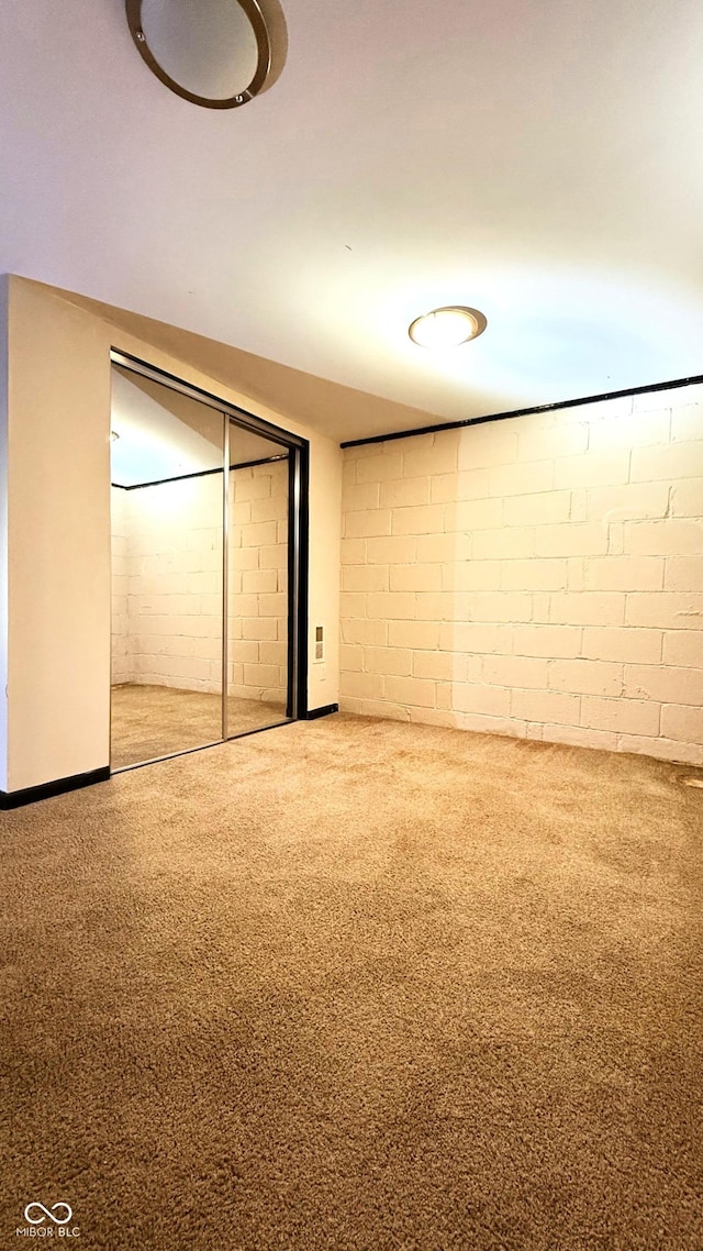4708 Haverford Ave, Indianapolis, IN 46205 - unfurnished bedroom featuring concrete block wall, carpet flooring, and a closet