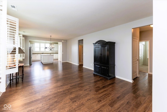 12820 Gloria Dr, Fishers, IN 46037 - unfurnished living room featuring a chandelier and dark wood-type flooring