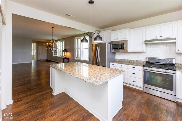 12820 Gloria Dr, Fishers, IN 46037 - kitchen with stainless steel appliances, under cabinet range hood, a center island, a chandelier, and backsplash