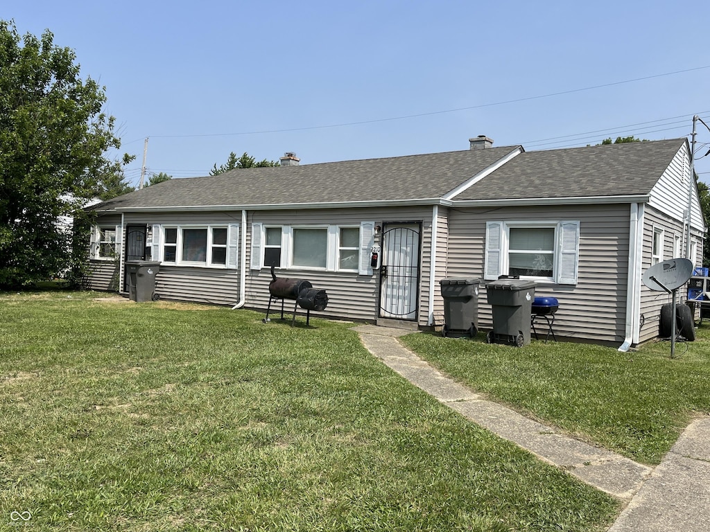 2208 Admiral Dr, Indianapolis, IN 46219 - view of front of home featuring a chimney, a front yard, and roof with shingles