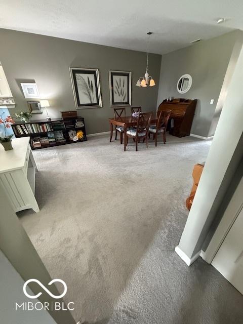 5304 Appleseed Way, Indianapolis, IN 46217 - carpeted living room with baseboards and a chandelier