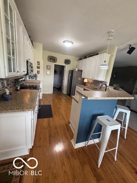 5304 Appleseed Way, Indianapolis, IN 46217 - kitchen with stainless steel appliances, white cabinetry, dark wood finished floors, and glass insert cabinets