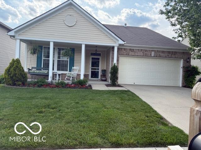 5304 Appleseed Way, Indianapolis, IN 46217 - ranch-style house with covered porch, driveway, an attached garage, and a front yard
