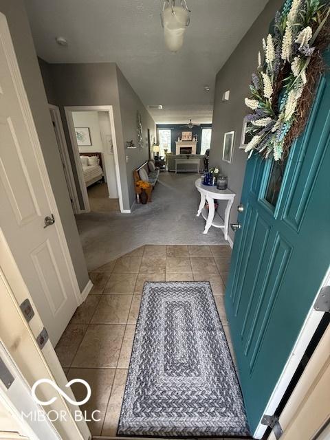 5304 Appleseed Way, Indianapolis, IN 46217 - carpeted foyer entrance with tile patterned floors, baseboards, and a fireplace with raised hearth