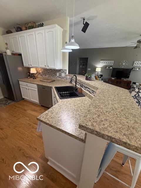 5304 Appleseed Way, Indianapolis, IN 46217 - kitchen with a sink, a peninsula, white cabinetry, and appliances with stainless steel finishes