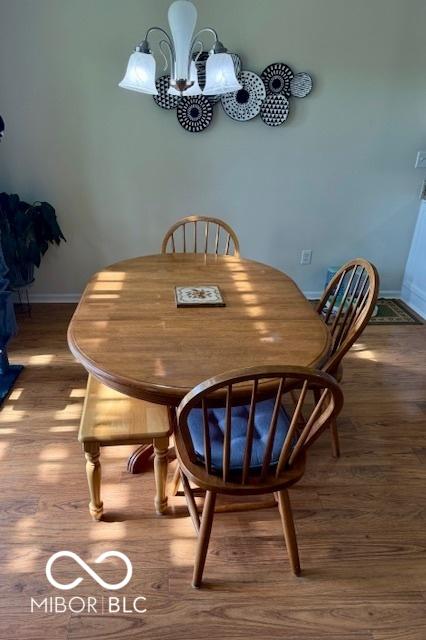 5304 Appleseed Way, Indianapolis, IN 46217 - dining area with a chandelier, wood finished floors, and baseboards