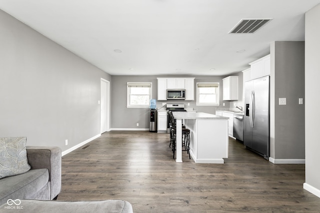 258 N Green Springs Rd, Indianapolis, IN 46214 - kitchen featuring stainless steel appliances, open floor plan, a kitchen island, white cabinetry, and a breakfast bar