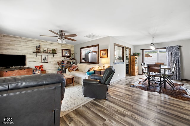 527 E 125 S, Williamsport, IN 47993 - living room featuring a ceiling fan, wooden walls, wood finished floors, and baseboards